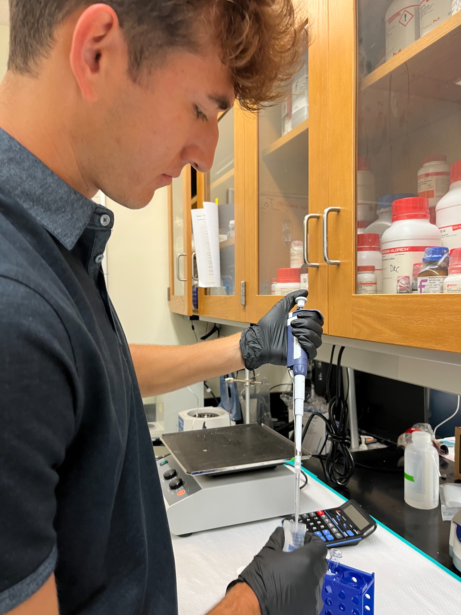 Eric using a pipette at the laboratory bench.