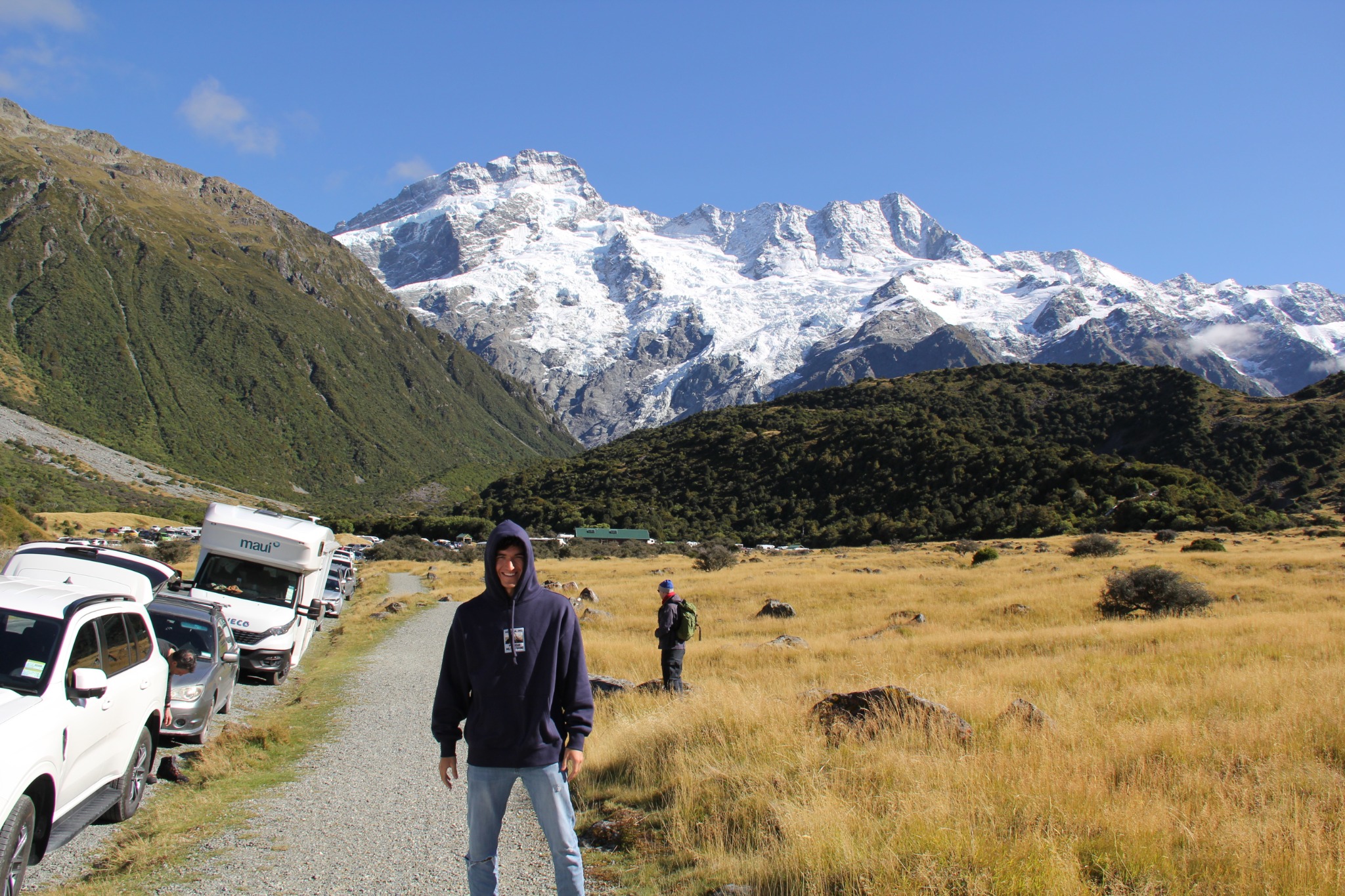Eric outdoors in a valley beneath snow-covered mountains.